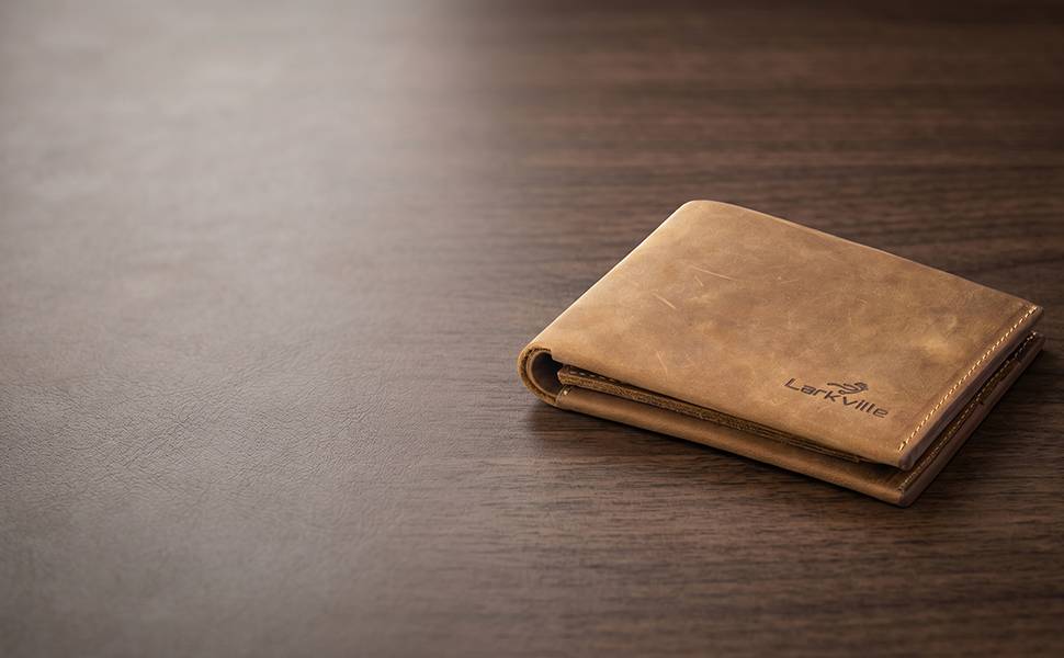 A leather bifold wallet in its branded gift box with tissue wrap